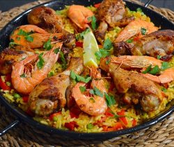 Spaanse Paella met grote garnalen en drumsticks in een paella pan