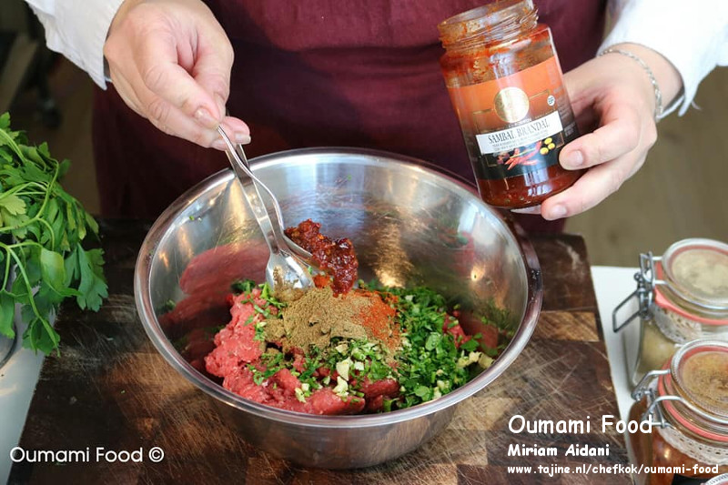 Gehaktbroodjes met pesto en cheddarkaas kruiden en sambal toevoegen aan gehakt